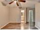 Bedroom with wood-look floors, ceiling fan, and doorway to a bathroom at 5987 Turfway Park Ct, Sugar Hill, GA 30518