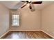 Cozy bedroom features wood-look floors, a ceiling fan, and a window with wood blinds at 5987 Turfway Park Ct, Sugar Hill, GA 30518