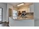 Modern kitchen with white cabinets, a peninsula with granite counters, and stainless steel appliances at 5987 Turfway Park Ct, Sugar Hill, GA 30518
