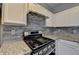 Stove detail with stainless steel appliances and stone tile backsplash at 5987 Turfway Park Ct, Sugar Hill, GA 30518