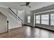 Bright living room with wood-look floors, a staircase, a ceiling fan and large windows at 5987 Turfway Park Ct, Sugar Hill, GA 30518