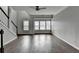 Bright living room featuring wood-look floors, ceiling fan, and large windows at 5987 Turfway Park Ct, Sugar Hill, GA 30518