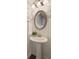 Charming powder room with pedestal sink, decorative mirror, and elegant wallpaper at 1962 Bainbridge Ln, Atlanta, GA 30345