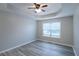 Cozy bedroom with modern gray flooring, tray ceiling, ceiling fan and natural light from a large window at 301 Thorn Thicket Dr, Rockmart, GA 30153