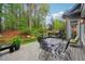 Back deck featuring a dining table, grill, and well manicured yard at 135 High Point Walk, Atlanta, GA 30342