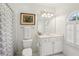Bright bathroom with white cabinets, shower with curtain, and a large window with plantation shutters at 135 High Point Walk, Atlanta, GA 30342