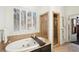 A soaking tub with deck, large shuttered window, and a glass enclosed shower at 135 High Point Walk, Atlanta, GA 30342