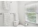 Clean white bathroom with towel racks, a toilet, and a window with blinds at 135 High Point Walk, Atlanta, GA 30342