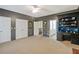 Spacious bedroom featuring a ceiling fan, neutral carpet, white trim and doors, and a built in desk at 135 High Point Walk, Atlanta, GA 30342
