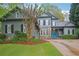 Charming two-story home featuring stone accents, a well-manicured lawn, and a vibrant blue front door at 135 High Point Walk, Atlanta, GA 30342