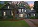 Charming two-story home featuring stone accents, a well-manicured lawn, and a vibrant blue front door at dusk at 135 High Point Walk, Atlanta, GA 30342