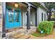 Inviting front porch with stone steps, black columns, and a vibrant blue double door at 135 High Point Walk, Atlanta, GA 30342