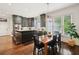Cozy kitchen with black cabinets, an island with seating, and a dining area at 135 High Point Walk, Atlanta, GA 30342