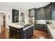 Spacious kitchen featuring black cabinets, stainless steel appliances, and a center island with a cooktop at 135 High Point Walk, Atlanta, GA 30342