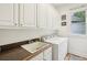 Clean laundry room featuring a utility sink, countertop, upper cabinets, and a washer/dryer at 135 High Point Walk, Atlanta, GA 30342