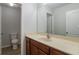 Bathroom featuring a sink with cabinets, toilet in the other room, and a large mirror at 1498 Scenic Pines Dr, Lawrenceville, GA 30044