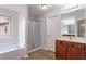 Bright bathroom with a tub, separate glass-door shower, and wooden vanity at 1498 Scenic Pines Dr, Lawrenceville, GA 30044