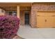 Close up exterior featuring stone accents, an attached two-car garage, and lovely plants at 1498 Scenic Pines Dr, Lawrenceville, GA 30044