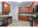 Kitchen with wooden cabinetry, dark countertops, tile backsplash, and stainless appliances at 1498 Scenic Pines Dr, Lawrenceville, GA 30044
