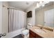 Comfortable bathroom featuring a tub with shower, functional cabinets, and ample lighting at 1741 Liberty Nw Pkwy, Atlanta, GA 30318