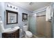 Bright bathroom featuring a glass shower, wood cabinet, and a classic sink and mirror combination at 1741 Liberty Nw Pkwy, Atlanta, GA 30318