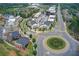 Aerial view of a vibrant community with charming townhomes, lush landscaping, and a roundabout, creating a welcoming atmosphere at 2200 Cortland Rd, Milton, GA 30009