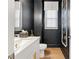 Stylish powder room with dark walls, modern vanity, and elegant decor at 2200 Cortland Rd, Milton, GA 30009