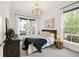 Bright bedroom features two windows, a modern light fixture, and a well-designed furniture layout at 2200 Cortland Rd, Milton, GA 30009