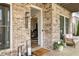 Charming front porch with brick facade, stylish seating, and 'welcome' mat at 2200 Cortland Rd, Milton, GA 30009