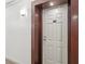 Condo front door featuring the unit number and a wall sconce, framed by dark trim at 3481 Lakeside Ne Dr # 2203, Atlanta, GA 30326