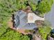 Aerial view of home showcasing the roof, driveway, landscaping, and surrounding trees at 545 Slane Trce, Roswell, GA 30076