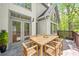 An outdoor dining space on a stone patio, shaded by trees and with views of the backyard at 545 Slane Trce, Roswell, GA 30076
