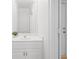 A bright half bathroom with a white vanity, a large mirror, and a view of a door to the exterior at 545 Slane Trce, Roswell, GA 30076