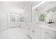 This elegant bathroom suite is well-lit and offers double sinks, white cabinets, and lots of mirrors at 545 Slane Trce, Roswell, GA 30076
