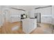 Bright kitchen featuring white cabinets, stainless steel appliances, central island, and hardwood flooring throughout the space at 545 Slane Trce, Roswell, GA 30076