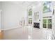 Bright living room with tall windows, fireplace, and tile flooring that leads to the entryway with stairs to the upper level at 545 Slane Trce, Roswell, GA 30076