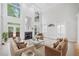 Spacious living room with high ceilings, a fireplace, large windows, built-in cabinets, and comfortable seating arrangements at 545 Slane Trce, Roswell, GA 30076