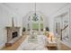 A bright living room with high ceilings, a stone fireplace, and large windows with backyard views at 545 Slane Trce, Roswell, GA 30076