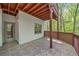 Covered patio with patterned tile, wooden railings, and a view of the lush green foliage at 545 Slane Trce, Roswell, GA 30076