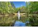 Scenic pond with a central fountain, reflecting the surrounding trees and sky, creating a tranquil setting at 545 Slane Trce, Roswell, GA 30076