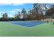 Well-maintained tennis courts with green and blue surfaces, surrounded by trees, offering a premium recreational amenity at 545 Slane Trce, Roswell, GA 30076