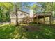 Expansive backyard featuring a wooden deck, lush green lawn, and mature trees at 904 Little River Ln, Woodstock, GA 30189