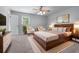 This spacious bedroom features a ceiling fan, two chairs, and a large bed with a wood headboard at 904 Little River Ln, Woodstock, GA 30189