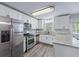 Modern kitchen with stainless steel appliances, white cabinets, and granite countertops at 904 Little River Ln, Woodstock, GA 30189