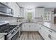 Well-equipped kitchen featuring stainless steel appliances, white cabinets, and granite countertops at 904 Little River Ln, Woodstock, GA 30189