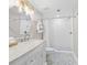 Modern bathroom with a single vanity and walk-in shower featuring white tile and glass door at 13 E Palmetto St, Porterdale, GA 30014