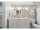 Stylish bathroom featuring a double vanity with elegant lighting fixtures and marble countertop at 13 E Palmetto St, Porterdale, GA 30014