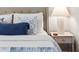 A bedside table with decor is next to a well-decorated bed with throw pillows and blankets at 13 E Palmetto St, Porterdale, GA 30014
