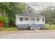 A charming home exterior features white siding, a grey brick foundation, and a small front porch at 13 E Palmetto St, Porterdale, GA 30014