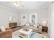 Warm living room featuring hardwood floors, a leather sofa, and plenty of natural light at 13 E Palmetto St, Porterdale, GA 30014